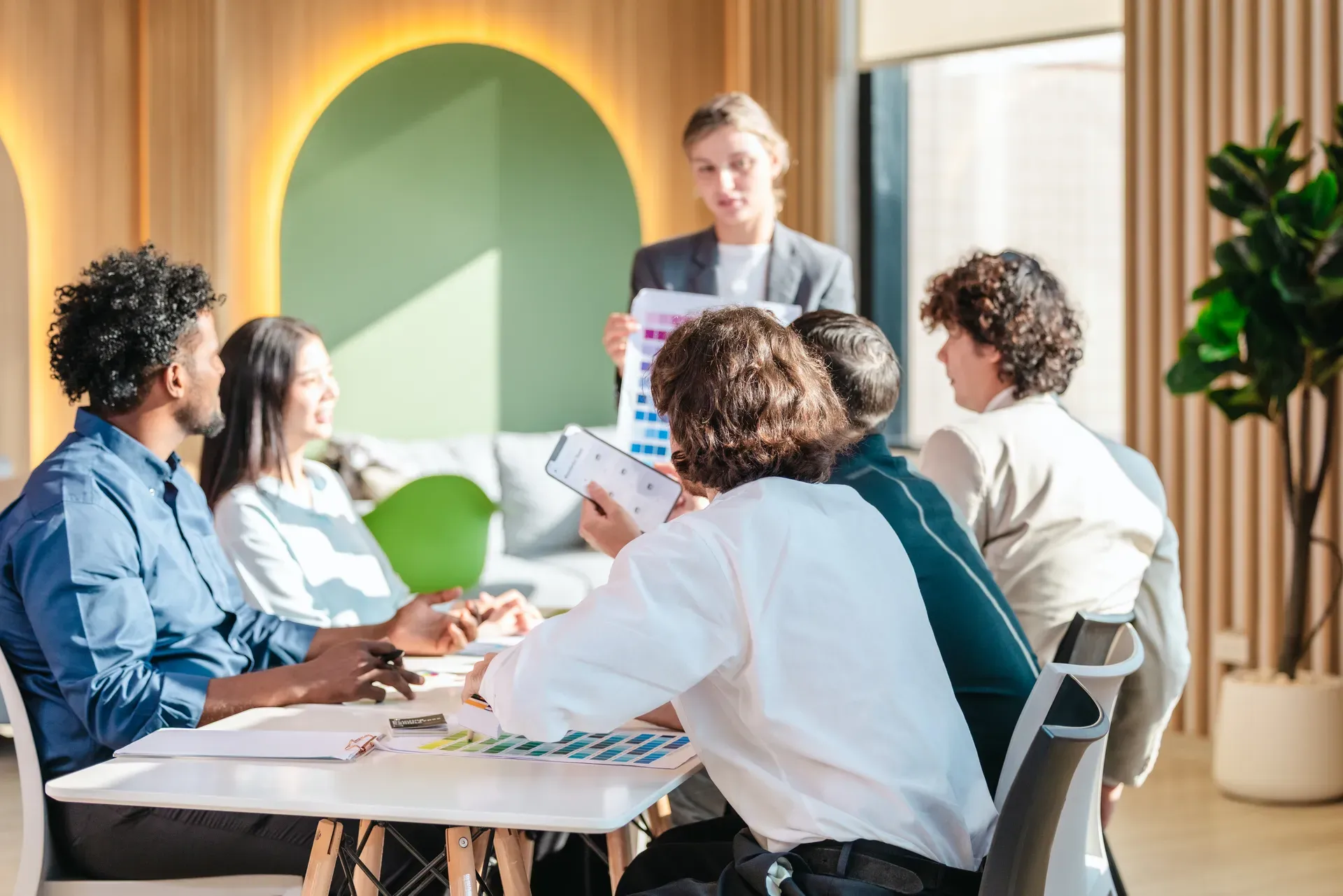 Groep mensen in overleg aan een tafel in een licht kantoor